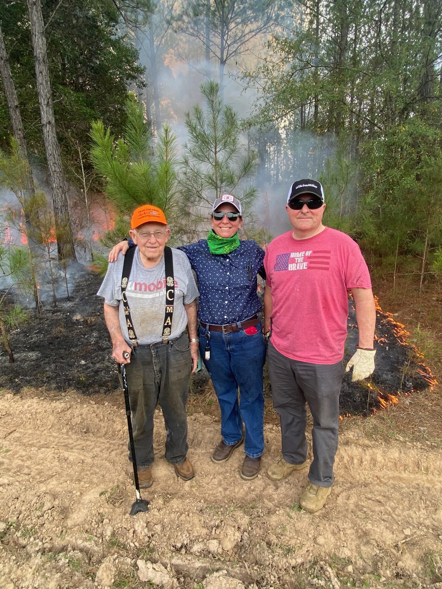 Three landowners standing in front of a prescribed burn.